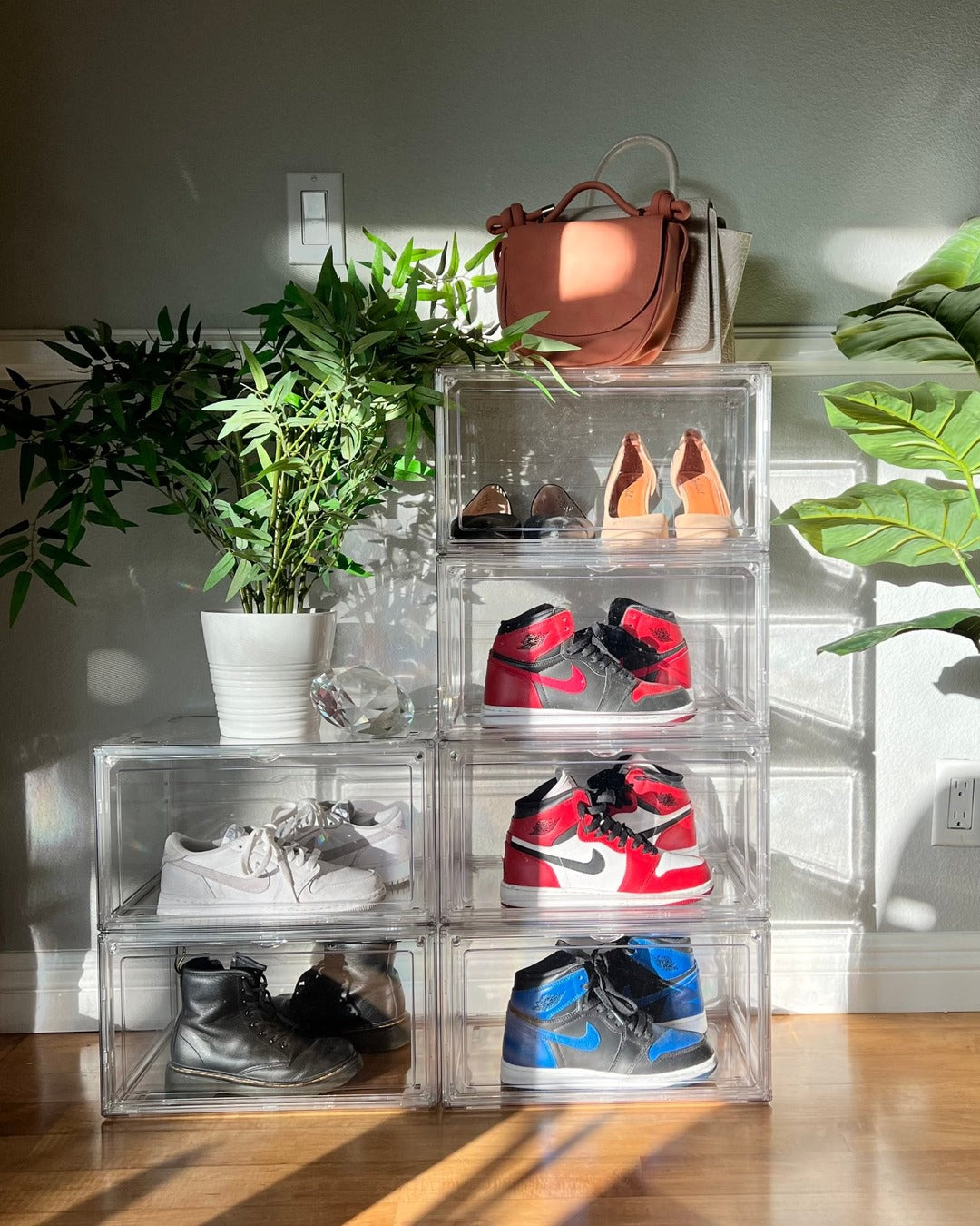 Eight stacked clear shoe boxes holding heels, Jordans, boots and a handbag