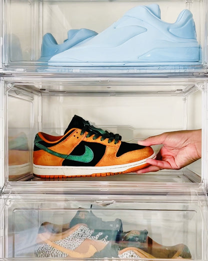 Hand taking a sneaker from a stack of clear shoe storage boxes