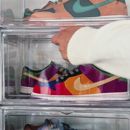 Video of a hand opening the side door of a stacked clear shoe box and taking out a sneaker